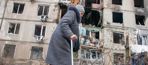 März 2022: Seniorin geht in der Nähe eines Wohnhauses, das nach Beschuss durch die russischen Besatzer in einem Wohngebiet von Charkiw zerstört wurde.